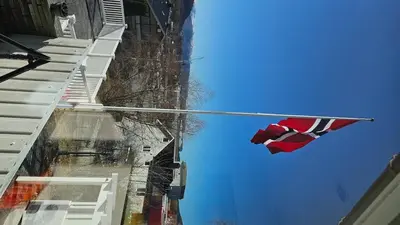 a flag hanging on a pole next to a building at Casa Knott 4 Bedroom in Ulstein