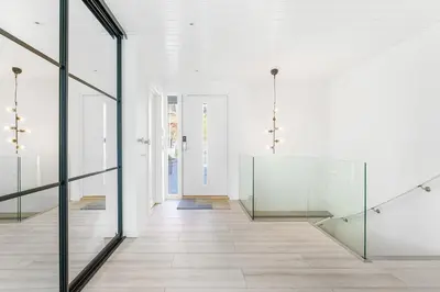 a hallway with glass doors and a staircase at Casa Knott 4 Bedroom in Ulstein