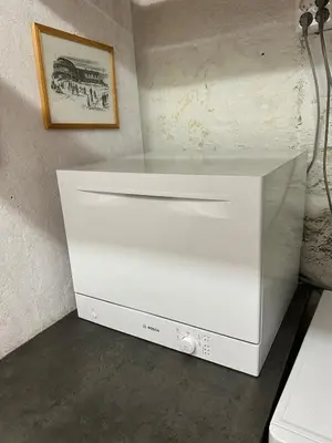 a white cooler sitting on the floor next to a wall at Liten studioleilighet meget sentralt i sentrum, 3 minutter fra torget in Trondheim