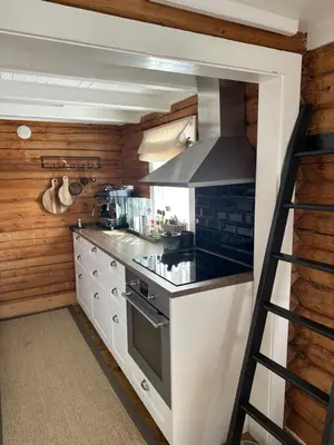 a kitchen with white cabinets and a stove top oven at Chalet Skogshorn in Markegardlian