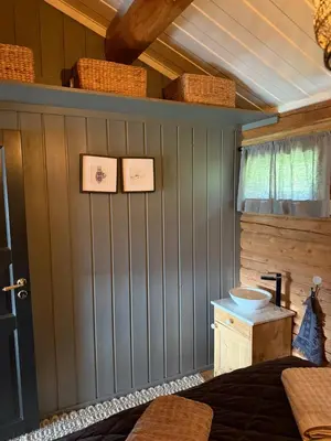 a bedroom with a bed and a sink and baskets on the wall at Chalet Skogshorn in Markegardlian