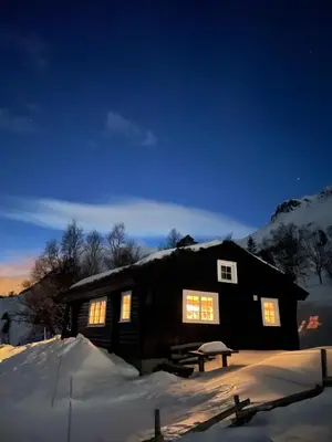 a log cabin in the snow at night at Chalet Skogshorn in Markegardlian