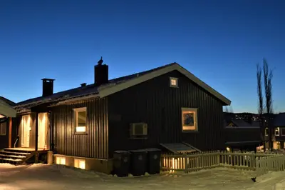 a black house with two trash cans in front of it at Spacious house close to Ski World Championship in Trondheim