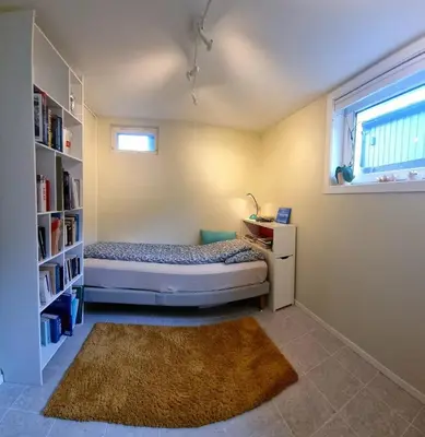 a bedroom with a bed and a book shelf at Spacious house close to Ski World Championship in Trondheim