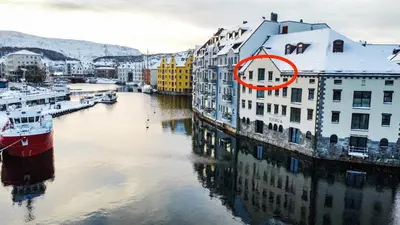 a group of buildings next to a river at MARINA LUXE - Two Bedrooms, High-End, Iconic Location & Private Parking in Ålesund