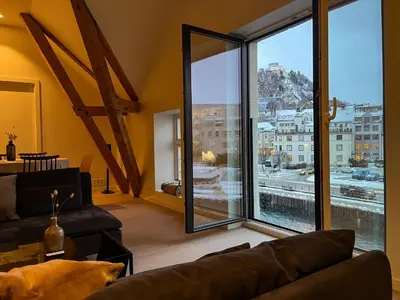 a living room with a couch and a large window at MARINA LUXE - Two Bedrooms, High-End, Iconic Location & Private Parking in Ålesund