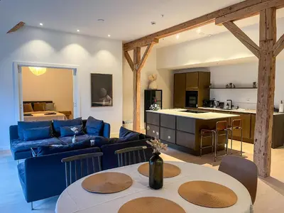 a living room with a blue couch and a kitchen at MARINA LUXE - Two Bedrooms, High-End, Iconic Location & Private Parking in Ålesund