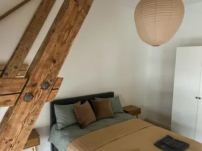a bedroom with a bed and a wooden beam at MARINA LUXE - Two Bedrooms, High-End, Iconic Location & Private Parking in Ålesund