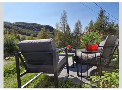two chairs and a table with flowers on a patio at Holiday Home Villa Gol in Gol