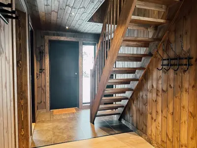 a wooden staircase in a room with a door at Modern Mountain Cabin - 3 Bedrooms - Sleeps 7 in Torpo