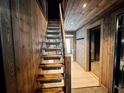 a wooden staircase in a house with wooden walls at Modern Mountain Cabin - 3 Bedrooms - Sleeps 7 in Torpo