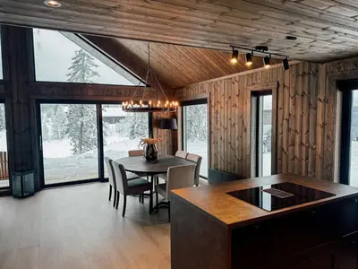 a kitchen and dining room with a table and chairs at Modern Mountain Cabin - 3 Bedrooms - Sleeps 7 in Torpo