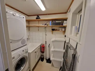 a small laundry room with a washer and dryer at Granåsen World Championship Stay Walk to Ski Arena in Trondheim