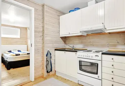 a kitchen with white cabinets and a bed in a room at Granåsen World Championship Stay Walk to Ski Arena in Trondheim