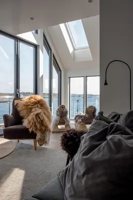 a living room with windows and a dog laying on a couch at Modern seaside holiday home in Bømlo