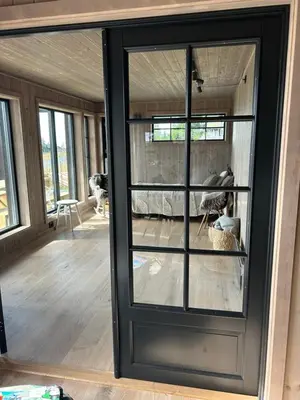 a large glass door in a room with a dog at Eksklusiv hytte Musdalsseter in Mo