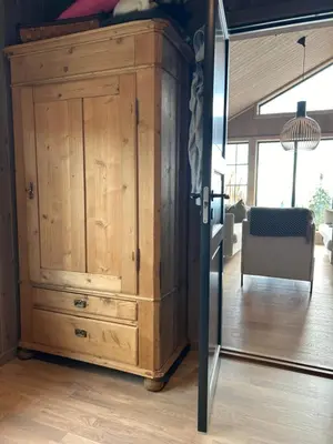 a wooden cabinet in a living room with a mirror at Eksklusiv hytte Musdalsseter in Mo