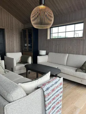 a living room with couches and a table and a chandelier at Eksklusiv hytte Musdalsseter in Mo