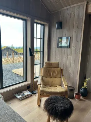 a living room with a chair and a large window at Eksklusiv hytte Musdalsseter in Mo