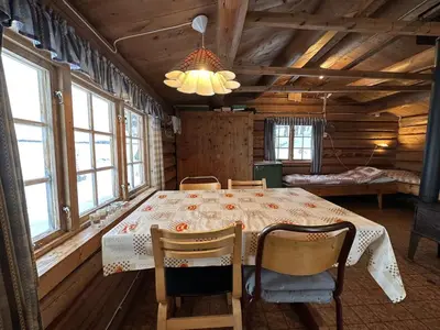 a dining room with a table in a cabin at Family cabin by the lake at Haugen, Femundsmarka in Elga