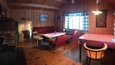 a dining room with a table and chairs and a window at Simple family cabin at Haugen, Femundsmarka in Elga