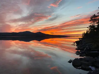 a sunset over a body of water with the sky at Simple family cabin at Haugen, Femundsmarka in Elga
