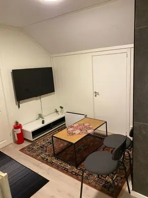 a living room with a table and a television at Charming 2-bedroom loft by UNESCO site Jotunheimen and Vettifossen! in Årdalstangen