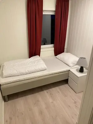 a small bed in a room with a window at Charming 2-bedroom loft by UNESCO site Jotunheimen and Vettifossen! in Årdalstangen