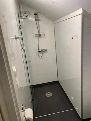 a bathroom with a shower with a glass door at Charming 2-bedroom loft by UNESCO site Jotunheimen and Vettifossen! in Årdalstangen