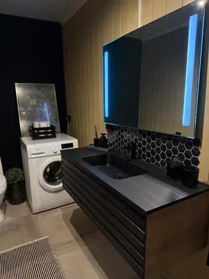 a bathroom with a sink and a washing machine at Peace in the heart of nature in Trysil