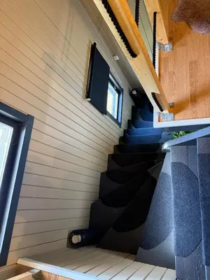 a staircase in a tiny house with two windows at Peace in the heart of nature in Trysil