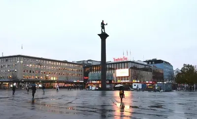 a city square with a statue of a cross on a pole at Delicate Central Apartment Trondheim in Trondheim
