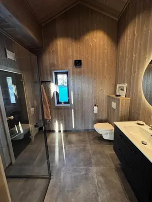 a bathroom with a toilet and a sink and a mirror at New modern cabin in Beitostølen in Beitostøl