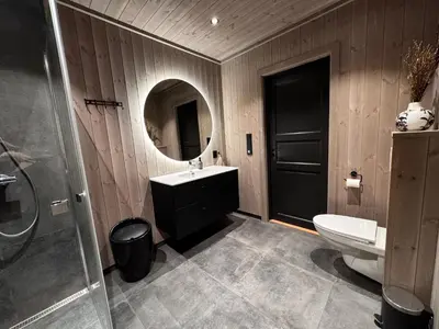 a bathroom with a sink and a toilet and a mirror at New modern cabin in Beitostølen in Beitostøl