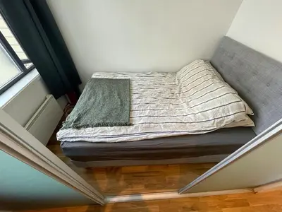 a bed in the corner of a room at Cozy 1-bedroom in quiet Ilsvika in Trondheim