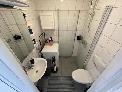 a bathroom with a shower and a sink and a toilet at Cozy 1-bedroom in quiet Ilsvika in Trondheim