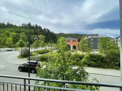 a car parked in a parking lot next to a street at Cozy 1-bedroom in quiet Ilsvika in Trondheim