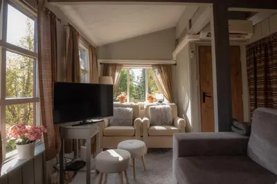 a living room with a couch and a tv and a window at Trysilfjellet Sør 17 in Trysil