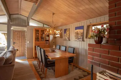 a dining room with a wooden table and chairs at Trysilfjellet Sør 17 in Trysil