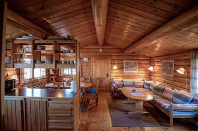 a wooden cabin with a table and a couch at Trysilfjellet Sør 204 in Trysil