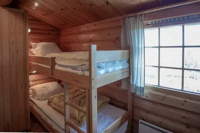 two bunk beds in a log cabin with a window at Trysilfjellet Sør 204 in Trysil