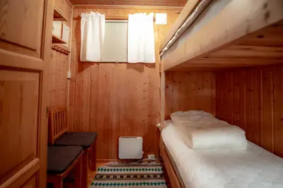 two bunk beds in a wooden room with a window at Trysilfjellet Nord 607 in Trysil
