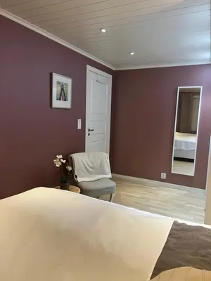 a bedroom with a bed and a chair and a mirror at House with 5 bedrooms very close to World Cup 25 in Granåsen in Trondheim