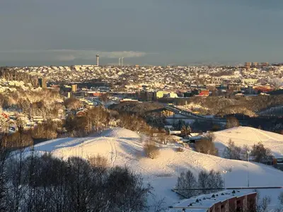 a city covered in snow with buildings in the background at House with 5 bedrooms very close to World Cup 25 in Granåsen in Trondheim