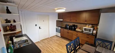 a kitchen with wooden cabinets and a table with chairs at Storgata 36B in Lillehammer