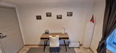 a desk with a chair and a lamp in a room at Storgata 36B in Lillehammer