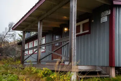 a house with a porch with a dog sitting on the porch at Trysilfjellet Nord 1017 in Trysil