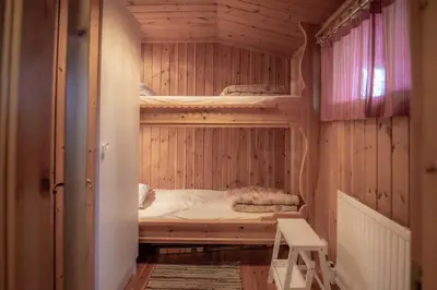 a bedroom with bunk beds in a wooden cabin at Trysilfjellet Nord 1017 in Trysil