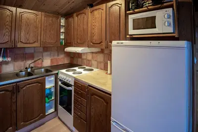 a kitchen with wooden cabinets and a white refrigerator at Trysilfjellet Nord 1017 in Trysil