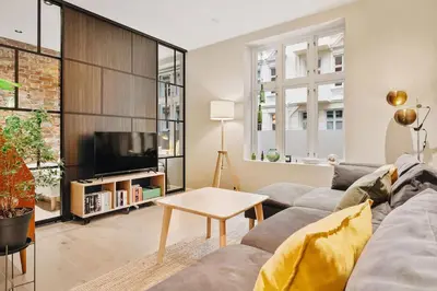 a living room with a couch and a tv at DINBNB Apartments Private terrace l 700 m to Bryggen l Modern in Bergen